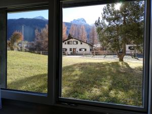 - une fenêtre donnant sur une cour avec une maison dans l'établissement Suretta2, à Splügen