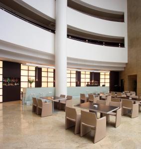 a dining room with tables and chairs and large windows at Hotel Abades Nevada Palace in Granada