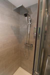 eine Dusche mit Duschkopf im Bad in der Unterkunft Amaya Six - Beautifully renovated with the latest tech & FAST Wi-Fi in Grantham