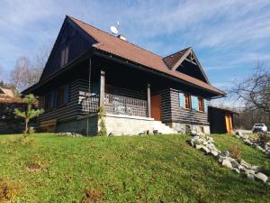 a house with a black roof on a hill at Chata Kolmanovci in Oščadnica