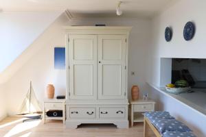 um quarto com um armário branco e uma mesa em Ferienwohnung-Kolberger em Westerland