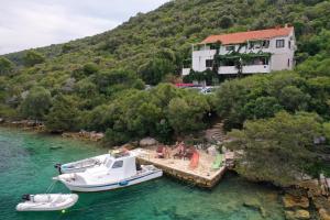 a boat is docked on a dock in the water at Apartmani Jagoda in Lastovo
