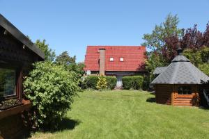 una casa con techo rojo y patio en Haus Seerobbe-Erdgeschosswohnung, en Fehmarn