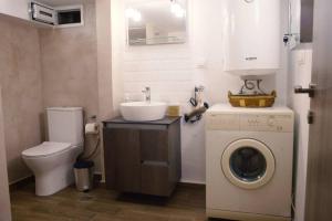 a bathroom with a washing machine and a sink at Στούντιο στο κέντρο της πόλης. in Volos +33 photos