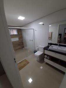 y baño con ducha, aseo y lavamanos. en APT 403 - Localização excelente Thermas Palace !!, en Piratuba