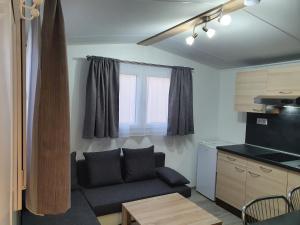 a living room with a couch and a kitchen at Bungalows Michalka - Podhájska in Podhájska