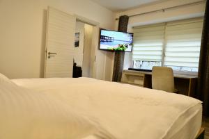 um quarto de hotel com uma cama e uma televisão de ecrã plano em W2 Ferienwohnung-32609 Hüllhorst em Hüllhorst