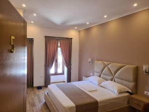 a bedroom with a large bed and a window at Guesthouse Arben Elezi in Berat