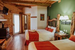 um quarto com 2 camas num chalé de madeira em The Lodge At Creel Eco - Hotel & Spa em Creel