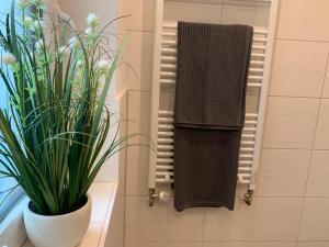 ein Badezimmer mit einem Handtuch und einer Topfpflanze in der Unterkunft Barrierefrei - 24Std-CHECK-IN kontaktlos - Kingsize Bed - W-LAN - Parkplatz W 3 in Bückeburg