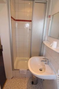 a bathroom with a sink and a shower at Kapitaenshaus-Lassen-Zimmer-Kajuete in Westerland