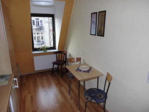 Zimmer mit einem Tisch, Stühlen und einem Fenster in der Unterkunft Sehr schöne 4 Raum Maisonette-Fewo mit 100qm + zentral & preiswert - T9 in Dresden