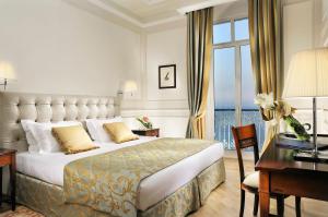 a hotel room with a large bed and a desk at Royal Hotel Sanremo in Sanremo