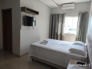 ein weißes Zimmer mit einem Bett und einem Fenster in der Unterkunft Master Hotel in Mundo Novo