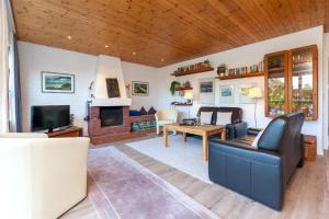 ein Wohnzimmer mit einem Sofa, einem Tisch und einem TV in der Unterkunft Bungalow Finlandia in Westerland