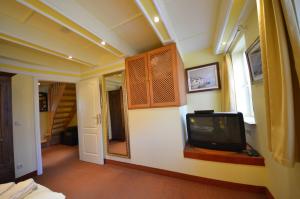 a room with a tv on a wall at Eck-Reethaus-Kirchhaus in Groß Zicker