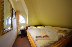 a bedroom with a bed with towels and a mirror at Eck-Reethaus-Kirchhaus in Groß Zicker
