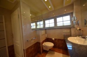 a bathroom with a toilet and a sink and a window at Eck-Reethaus-Kirchhaus in Groß Zicker +33 photos
