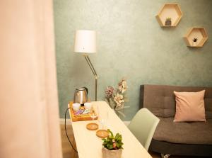 a room with a table with a lamp and a couch at Manolle Boutique in Bucharest
