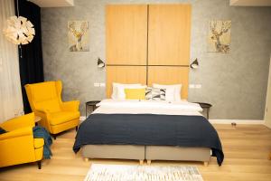 sypialnia z dużym łóżkiem i 2 żółtymi krzesłami w obiekcie Manolle Boutique Hotel w Bukareszcie