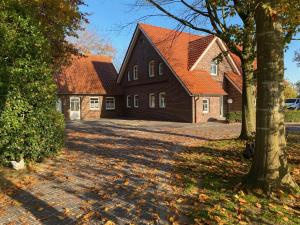 uma casa com telhados vermelhos e uma entrada em Ferien-am-Uhlenmeer Keine-Monteure em Apen
