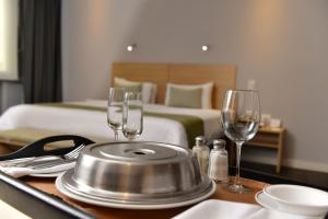 una camera d'albergo con un tavolo con bicchieri da vino e un letto di Unipark by Oro Verde Hotels a Guayaquil