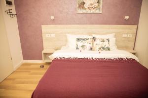 sypialnia z dużym łóżkiem i fioletowymi ścianami w obiekcie Manolle Boutique Hotel w Bukareszcie