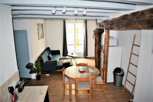 een woonkamer met een tafel en stoelen bij Gite Le Nid des Zoo Zio, 5mn Beauval, appartement terrasse centre-ville in Saint-Aignan