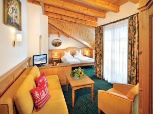 a hotel room with a couch and a bed at Hotel zum Hirschen in Zell am See