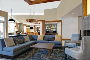 - un salon avec un canapé bleu et des chaises dans l'établissement Hyatt Place Jackson Ridgeland, à Ridgeland
