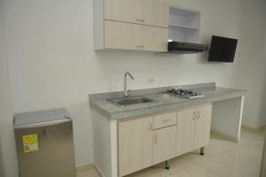 a kitchen with a sink and a trash can at Apartahotel Plaza de ángel 74 in Barranquilla