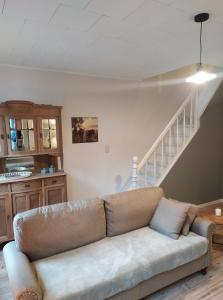 a living room with a couch and a staircase at La Roche ô Tour! - Gîte citadin in La Roche-en-Ardenne