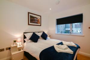a bedroom with a large bed with a window at Long Row Apartments in Nottingham City Centre in Nottingham