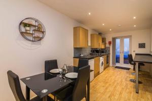 a kitchen and dining room with a table and chairs at Long Row Apartments in Nottingham City Centre in Nottingham