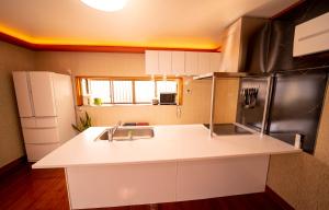 a kitchen with a sink and a refrigerator at Shiki no Sai in Mongawa