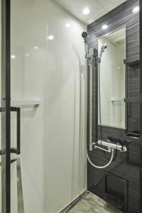 a bathroom with a shower and a mirror at Sakura Cross Hotel Shinjuku East Annex in Tokyo