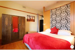 1 dormitorio con 1 cama grande con manta roja en NORD - North Hobart Apartments, en Hobart