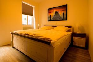 ein Schlafzimmer mit einem großen Bett mit gelben Wänden in der Unterkunft Frau Clara Haus - Ecke 1 in Eckernförde