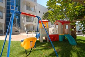 a playground in the grass in front of a building at Residence Costa Smeralda in Grottammare