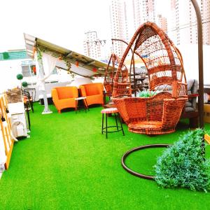 a room with green grass and chairs and a swing at The Antique in Busan