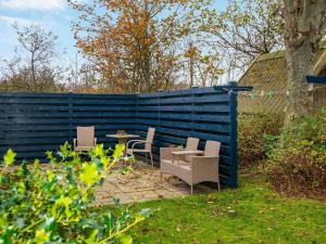 een achtertuin met een blauw hek en een tafel en stoelen bij 5 person holiday home in Egernsund in Egernsund