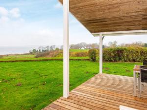 een veranda met een tafel en uitzicht op een veld bij 5 person holiday home in Egernsund in Egernsund