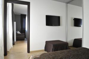 een slaapkamer met een spiegel en een tv aan de muur bij Casa Boffa in Barbaresco