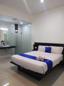 a bedroom with a large bed with towels on it at Puri Maju Hotel in Jakarta