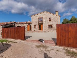 un chien assis devant une maison avec deux portes dans l'établissement Belvilla by OYO Cal Sant Miquel, à Castellolí