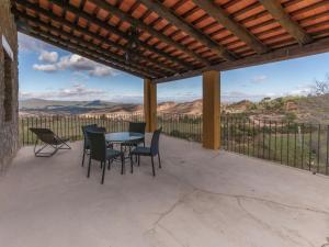 a patio with a table and chairs and a view at Belvilla by OYO Cal Sant Miquel in Castellolí