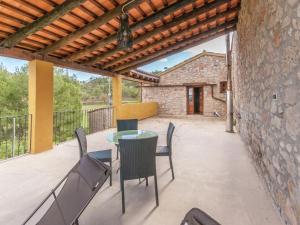 een patio met een tafel en stoelen en een gebouw bij Belvilla by OYO Cal Sant Miquel in Castellolí