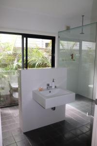 a white bathroom with a sink and a window at @LIZZIE in Elizabeth Beach