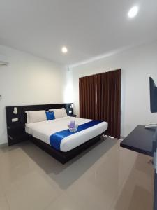 a bedroom with a large bed with blue and white sheets at Puri Maju Hotel in Jakarta