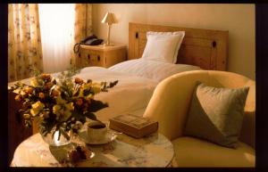 a bedroom with a bed and a table with a vase of flowers at Unser kleines Hotel Café Göbel in Laubach